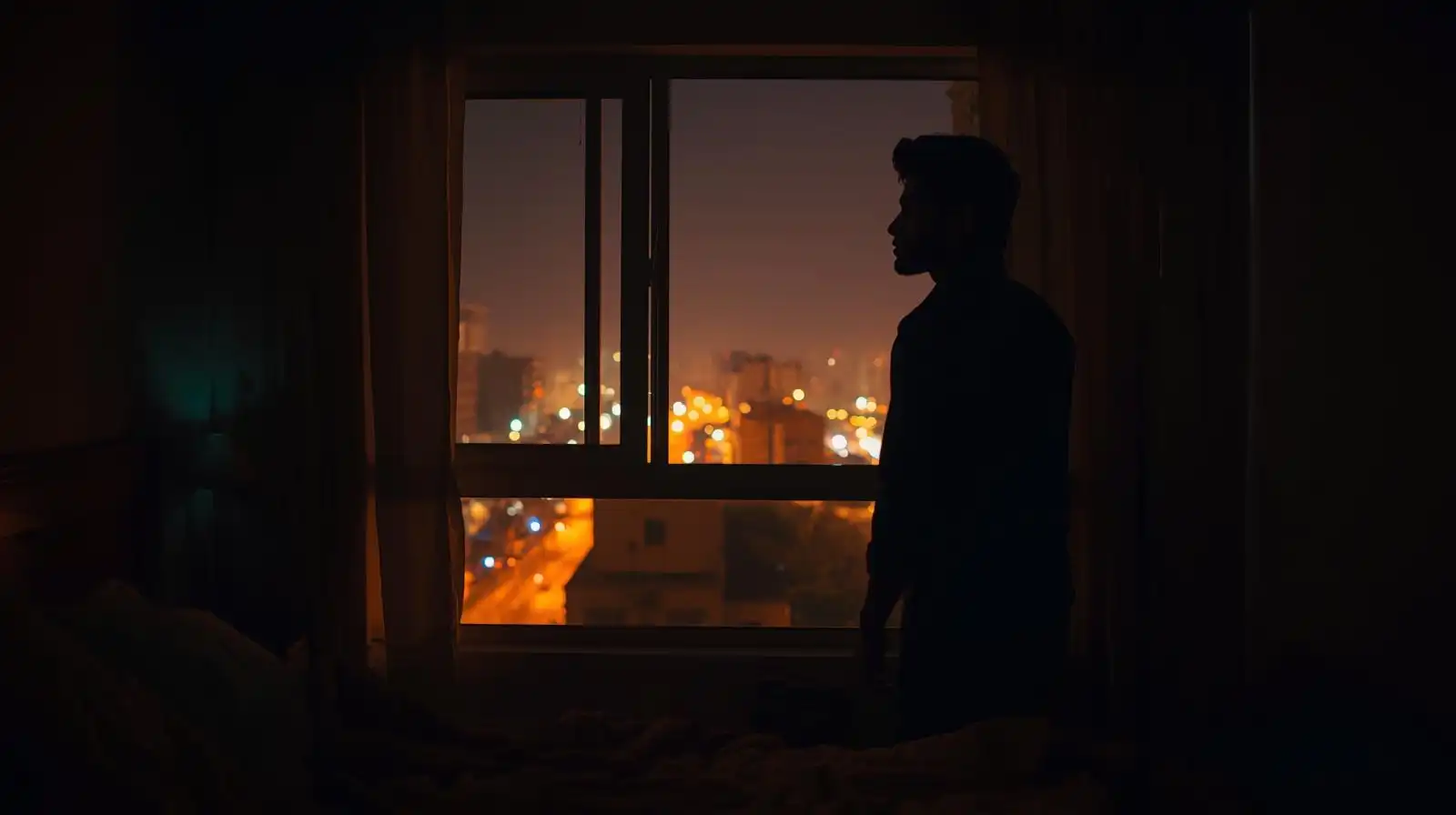 Person in quiet room looking outside, expressing loneliness and hope.